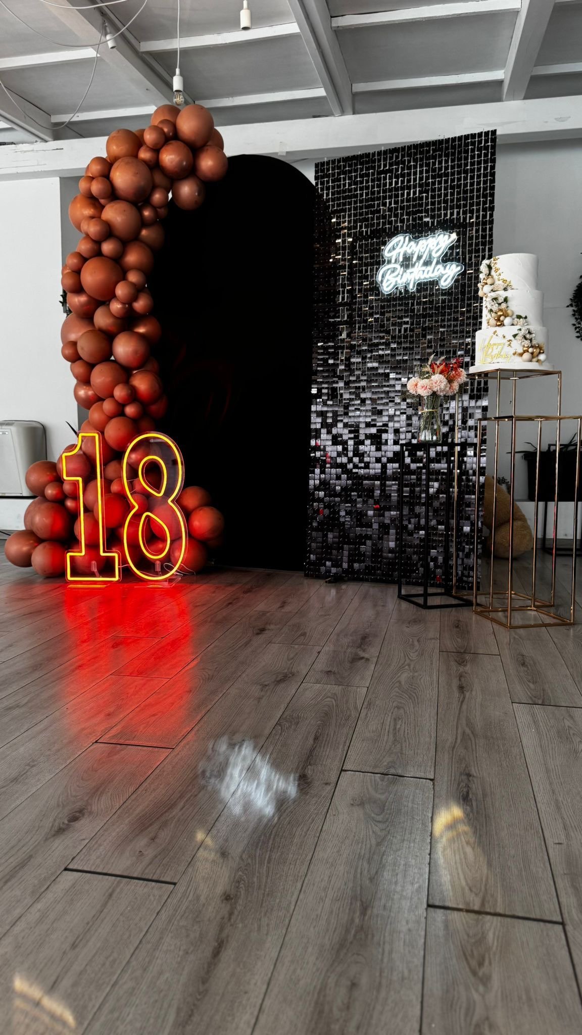 18esimo compleanno con arco di palloncini marroni, parete paillettes nera e neon 18