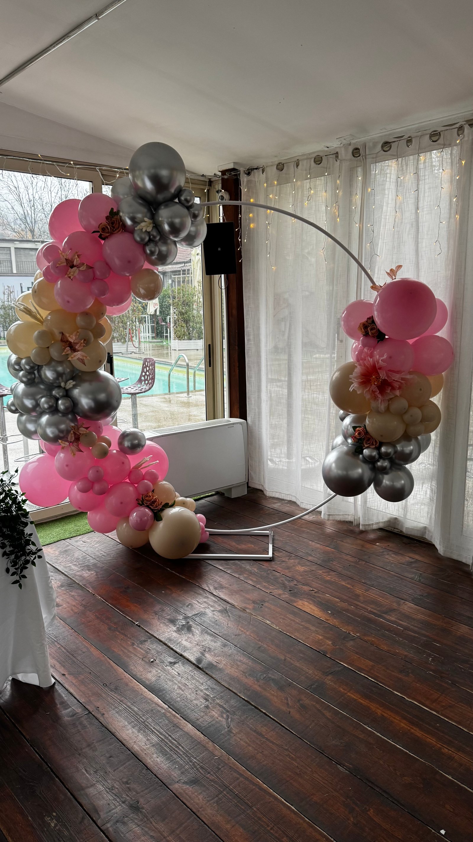 Arco circolare con palloncini rosa, argento e crema con fiori